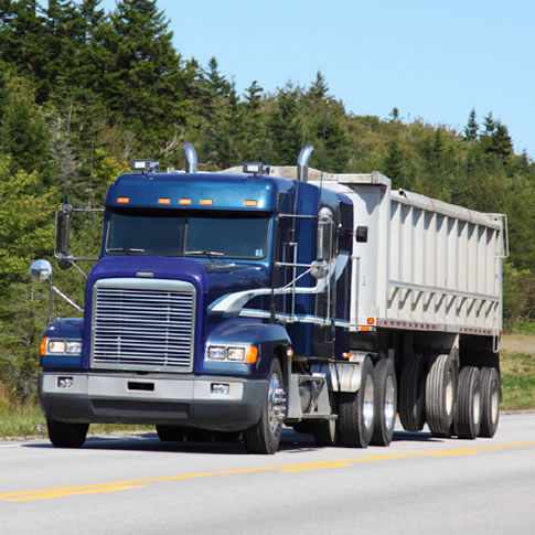 image of big rig on highway; forest background